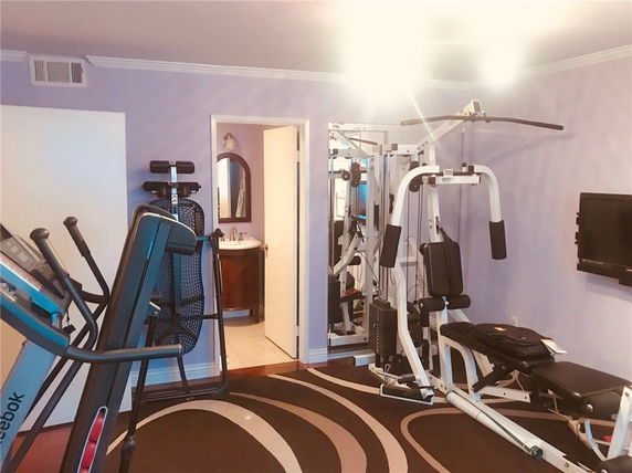 Indoor gym area with fitness equipment and a small bathroom.
