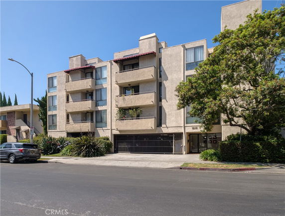 Front view of a multi-story apartment building with balconies.