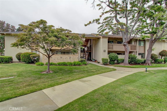 Front view of a multi-story residential building with a landscaped walkway.