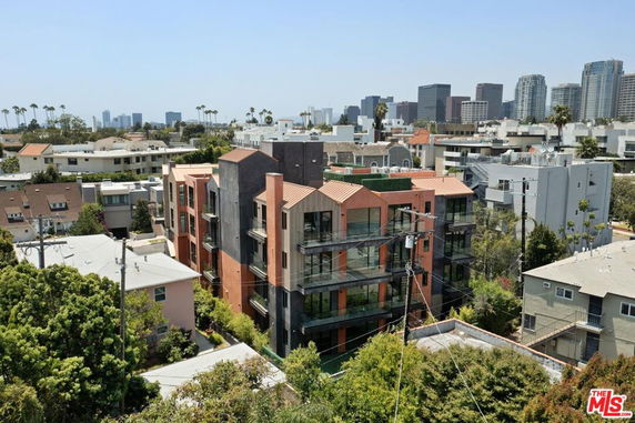 View of a multi-story building surrounded by other residential and commercial structures in an urban area.