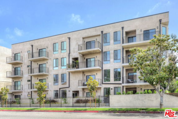 Front view of a multi-story apartment building with balconies.