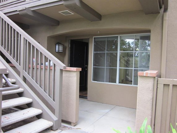 Front view of a house entrance with stairs and a window.