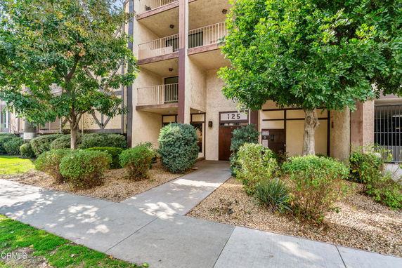 Front view of a multi-story apartment building with balconies.