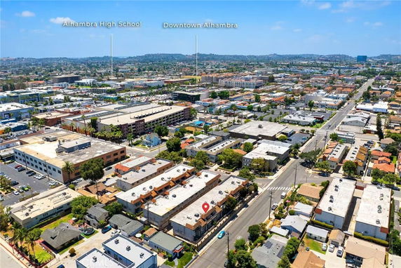 Aerial view of a cityscape with various residential and commercial buildings.