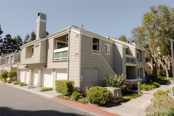 Front view of a two-story house with multiple garages and a chimney.