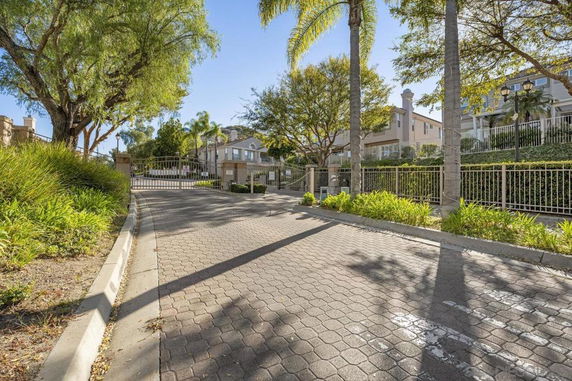 Front view of a gated residential community with multiple houses and landscaped surroundings.