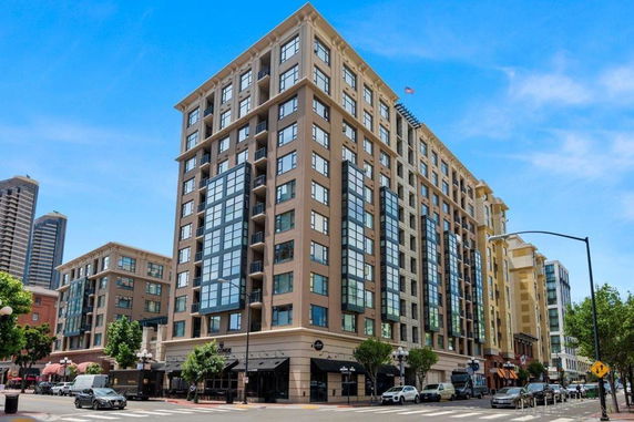 Front view of a multi-story building with large windows and a retail space on the ground level.