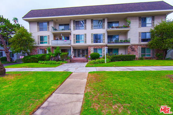 Front view of a three-story apartment building with multiple balconies.