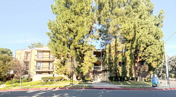 Front view of a multi-story apartment building with balconies.