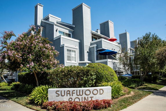 Front view of a multi-story residential building with balconies and multiple chimneys.