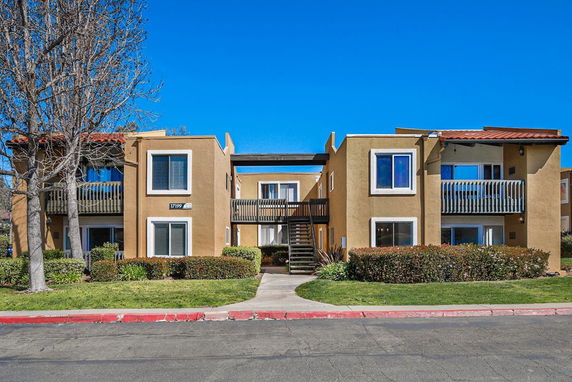 Front view of a two-story apartment building with balconies and a central staircase.