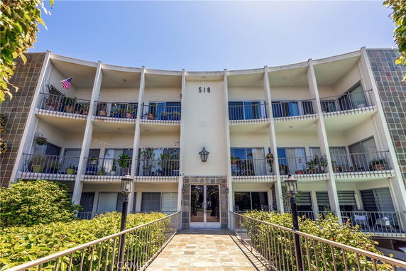 Front view of a multi-story apartment building with balconies.