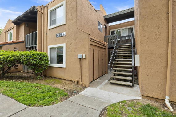 Front view of a two-story apartment building with an external staircase.