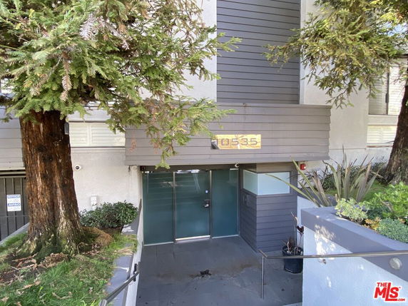Front view of a modern building entrance with glass doors.