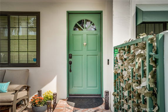 Front view of a house entrance with a green door and adjacent window.