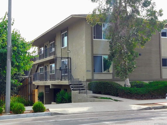 Front view of a two-story apartment building with external staircases.