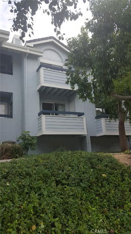 Front view of a house with multiple balconies and a gabled roof.