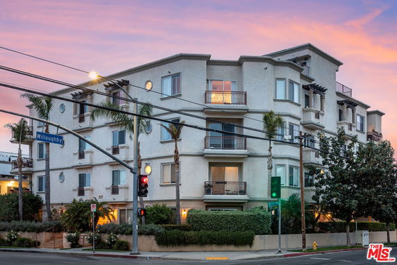 Front view of a multi-story apartment building with balconies.