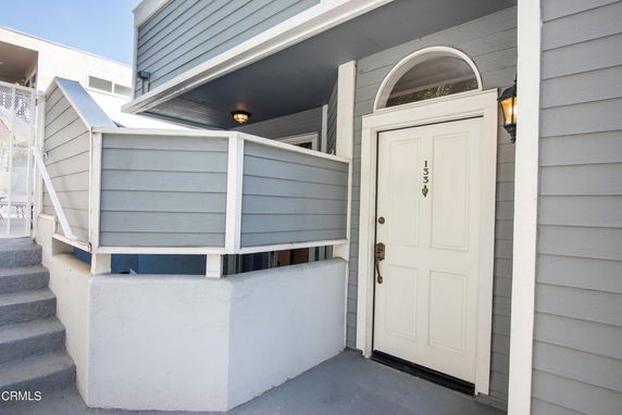 Front view of a house with a blue exterior and a white door numbered 133.