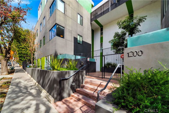 Front view of a multi-story modern building with green accents.