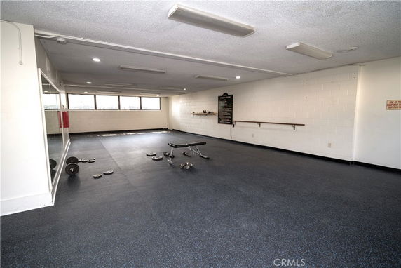 Interior view of a gym area with exercise equipment and large mirrors.