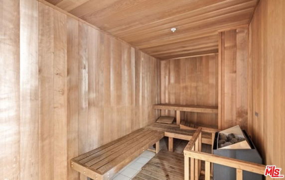 Wooden sauna room with benches and a heater.