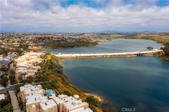 Aerial view showing buildings and a waterway with a bridge connecting across it.
