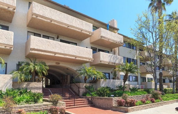 Front view of a multi-story apartment building with multiple balconies.