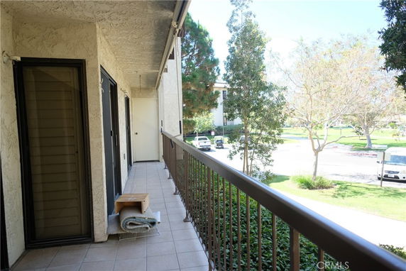 View from a balcony overlooking a street and park area.