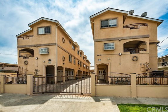 Front view of two adjacent multi-story buildings with a gated entrance.