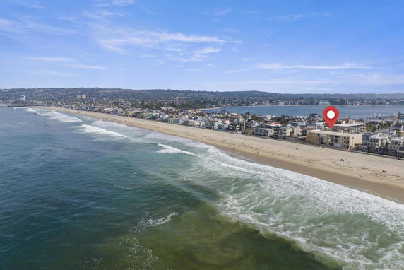 Panoramic view of a coastal area with a beach and ocean waves.