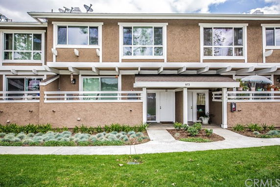 Front view of a two-story residential building with a pathway and landscaped area.