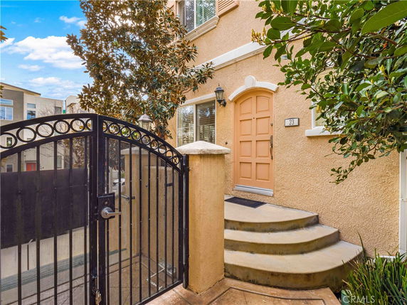 Front view of a house with a gated entrance and arched door.