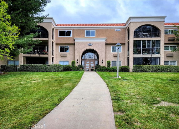 Front view of a multi-story building with large arched windows and a central entrance.