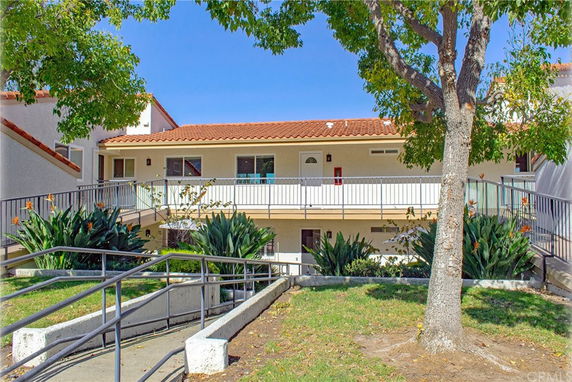 Front view of a two-story building with a red tile roof and balcony.