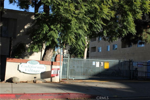 Front view of a gated residential building complex named California Village.