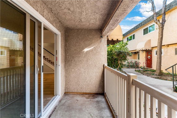 View of a small outdoor area with a building entrance and sliding glass doors leading to the interior.