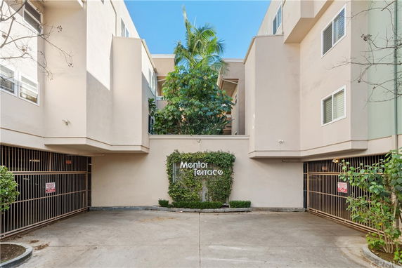 Front view of a multi-story building with a gated entrance.