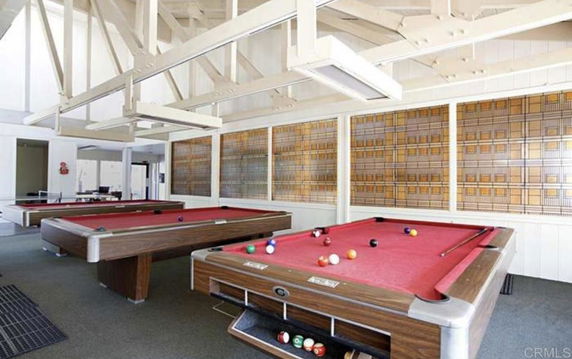 Room with pool tables and decorative wall panels.