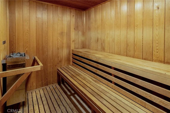 Interior view of a wooden sauna room with benches and a heater.