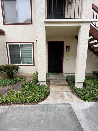 Front view of a house with a balcony and stairway.