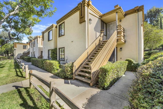 Front view of a two-story apartment building with exterior staircase.