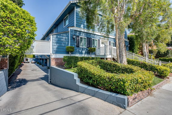 Front view of a two-story house with a blue exterior and a driveway.