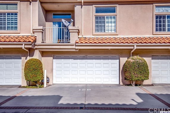 Front view of a townhouse with a double garage and a small balcony.