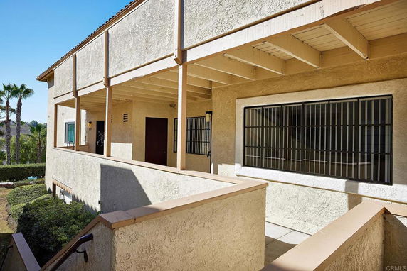Front view of a two-story building with a ramp leading to the entrance and fenced windows.