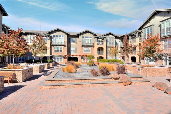 Front view of a multi-story residential building with landscaped courtyard.