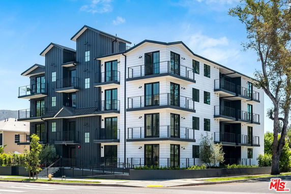 Front view of a multi-story modern apartment building with balconies.