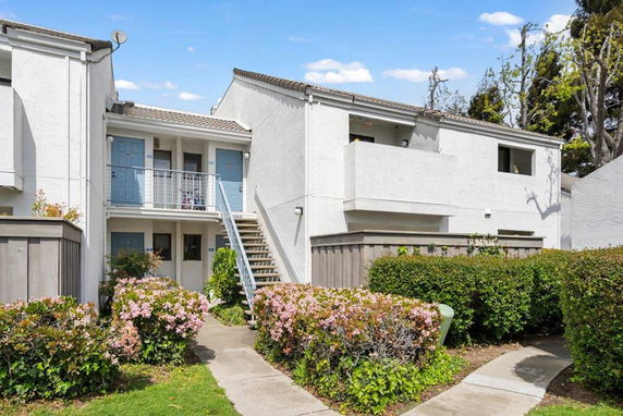 Front view of a two-story residential building with stairs leading to the second floor.