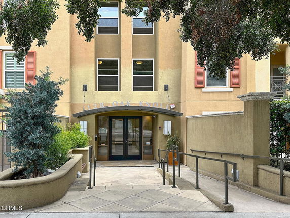 Front view of a multi-story building entrance with a ramp leading up to the door.