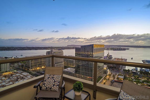 Panoramic view from a balcony overlooking water and city buildings.